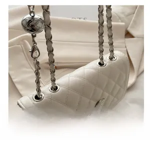Detail der weißen Stepptasche mit silberner Kette und verstellbarem Metallball