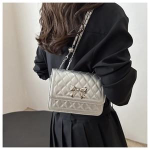 Detailansicht der silbernen Stepptasche mit Metallschleife und Kettenriemen
