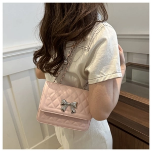 Trageansicht der rosa Stepptasche mit silberner Schleife und Kettenriemen