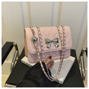 Detail der rosa gesteppten Tasche mit silberner Schleife und Metallkettenriemen