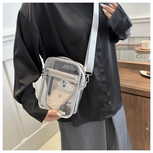 Détail d'un sac bandoulière transparent en PVC avec large sangle en tissu réglable