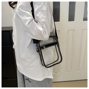 Vue détaillée du sac bandoulière transparent en PVC avec bordure noire et sangle réglable