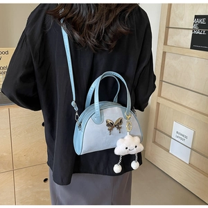 Détail du sac à bandoulière avec fermoir papillon argenté et breloque nuage pelucheux