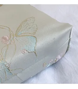 Detail of embroidered butterfly pattern on smooth satin fabric of a Chinese style tote bag