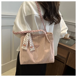 Detail of pink nylon tote bag featuring a decorative silk scarf and woven shoulder strap