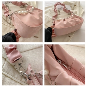 Detalle del bolso de nube fruncido rosa con correa de perlas y cremallera metálica
