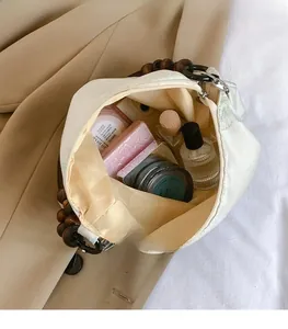 Close-up of beige floral embroidery tote bag showing spacious interior with cosmetics