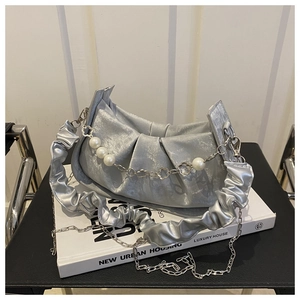 Detalle de bolso nube plateado plisado con cadena de perlas y acabado metálico