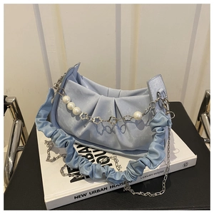 Detalle de bolso nube azul claro con textura de cuero plisado y cadena de perlas