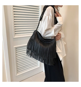 Detalle de flecos largos negros y asa de cuerda trenzada en un bolso grande hobo