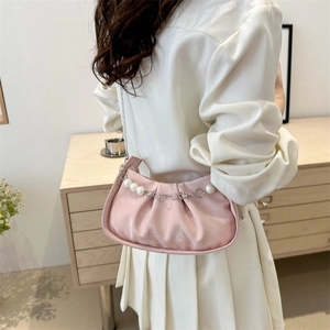 Bolso nube plisado rosa con cadena de perlas y corazones llevado como bolso de hombro