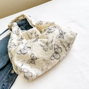 Détail du sac cabas blanc avec imprimés papillons gris et bords à franges