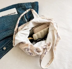 Intérieur spacieux du sac cabas en dentelle blanche avec texture florale et objets