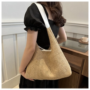 Detail der handgewebten Strohtasche mit weißem Lederriemen am Model im Sommer-Stil