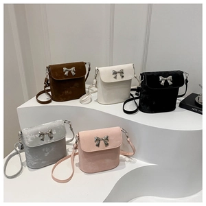 Bolsos tipo cubo mini coloridos con textura de gamuza y detalles de lazo metálico