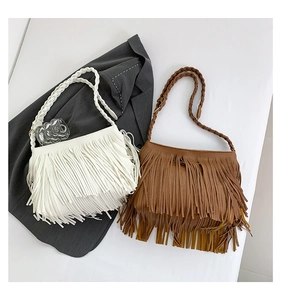 Detalle de bolsos bohemios con flecos y correas trenzadas en blanco y marrón