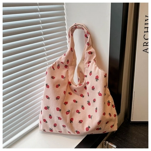 Detail of pink corduroy tote bag featuring cute strawberry print and soft ribbed texture