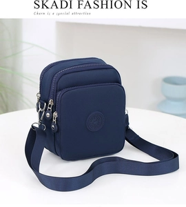 Detalle de bolso bandolera de nailon azul marino con bolsillos con cremallera