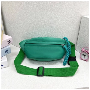 Détail du sac bandoulière en nylon vert avec tirettes de fermeture éclair tissées