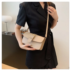 Detail of beige square crossbody bag featuring a premium gold adjustable buckle closure
