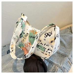 Close-up of white hobo bag featuring street style graffiti prints and artistic lettering