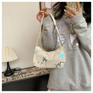 Close-up of cream hobo bag featuring street style graffiti letters and zipper closure