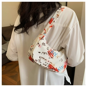 Detailed view of white artistic graffiti underarm bag on a model wearing white shirt