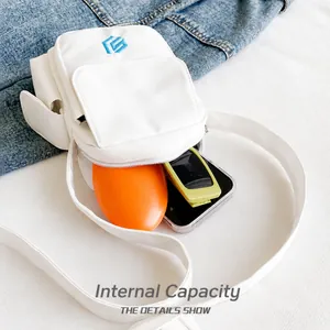 Internal capacity of white canvas crossbody square bag showing phone and power bank