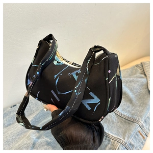 Detailed close-up of a black canvas underarm bag with vibrant graffiti letter prints