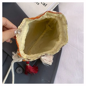 Detailweergave van de etnische bucket bag met gele stoffen voering en kwastjes