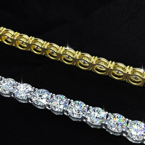 Macro shot of gold and silver Moissanite tennis bracelets with four-prong settings