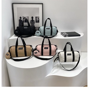 Detail of five 2-in-1 cylindrical canvas travel bags in diverse colors with mini pouches