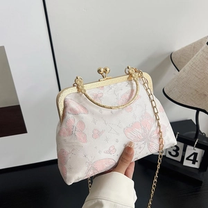 Detailed embroidery of pink butterflies on a white vintage frame bag with gold chain