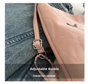Close-up of pink patent leather bag showing adjustable metal buckle and chain strap