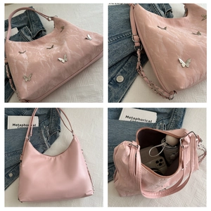 Detailed interior view of pink pleated shoulder bag showing large capacity and butterfly charms