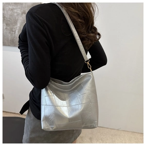 Silberne Metallic-Einkaufstasche mit geometrischem Design am Model präsentiert