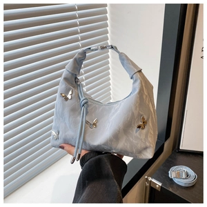 Detail of light blue crescent tote with pleats and silver butterfly ornaments