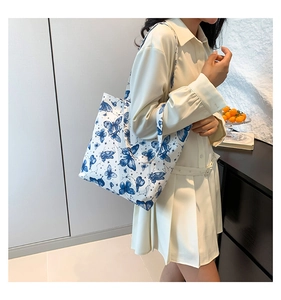 Lifestyle foto van de witte draagtas met blauwe vlinderprint voor de dagelijkse mode