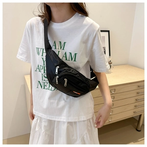 Detalle de un bolso bandolera negro de tela Oxford llevado por una modelo en un interior