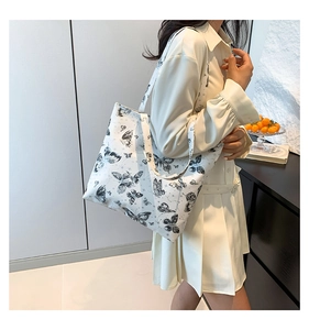 Detailweergave van vlinderprint shopper met materiaaltextuur en schouderriem