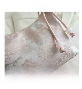 Detail of pink brocade jacquard bag featuring traditional garden scenery embroidery