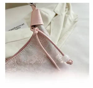 Macro shot of pink jacquard fabric with elegant tree patterns and leather strap detail