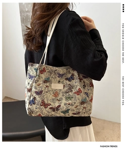 Detail of canvas tote bag featuring colorful butterfly embroidery and slim shoulder strap