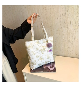 Detail van witte vlinder shopper met paarse pluche hanger voor dagelijks woon-werk