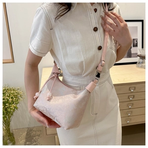 Pink jacquard shoulder bag with floral pattern worn by a model in a minimalist white dress