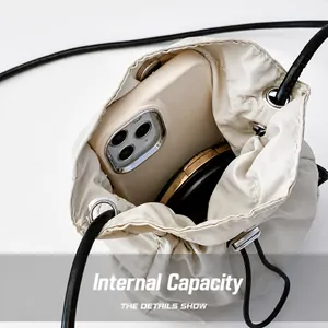 Dettaglio della borsa in tela con coulisse che mostra la capacità interna per cellulare