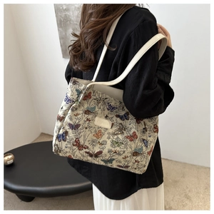 Detail showing high-capacity canvas tote bag with colorful butterfly patterns and leather straps