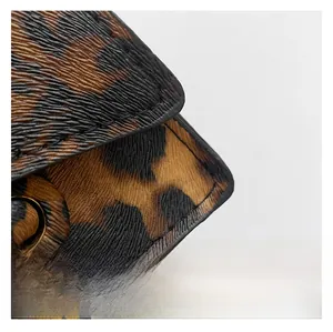 Close-up of leopard print leather bag with fine stitching and golden metal hardware