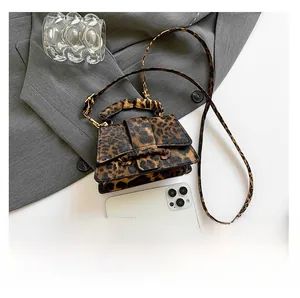 Close-up of leopard print crossbody bag showing textured faux leather and gold buckle