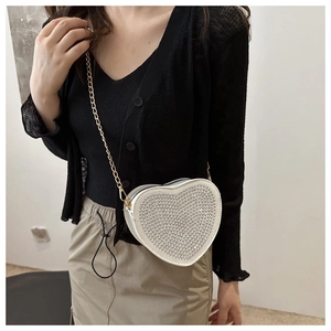 Dettaglio borsa a tracolla a forma di cuore con strass argentati brillanti e catena dorata